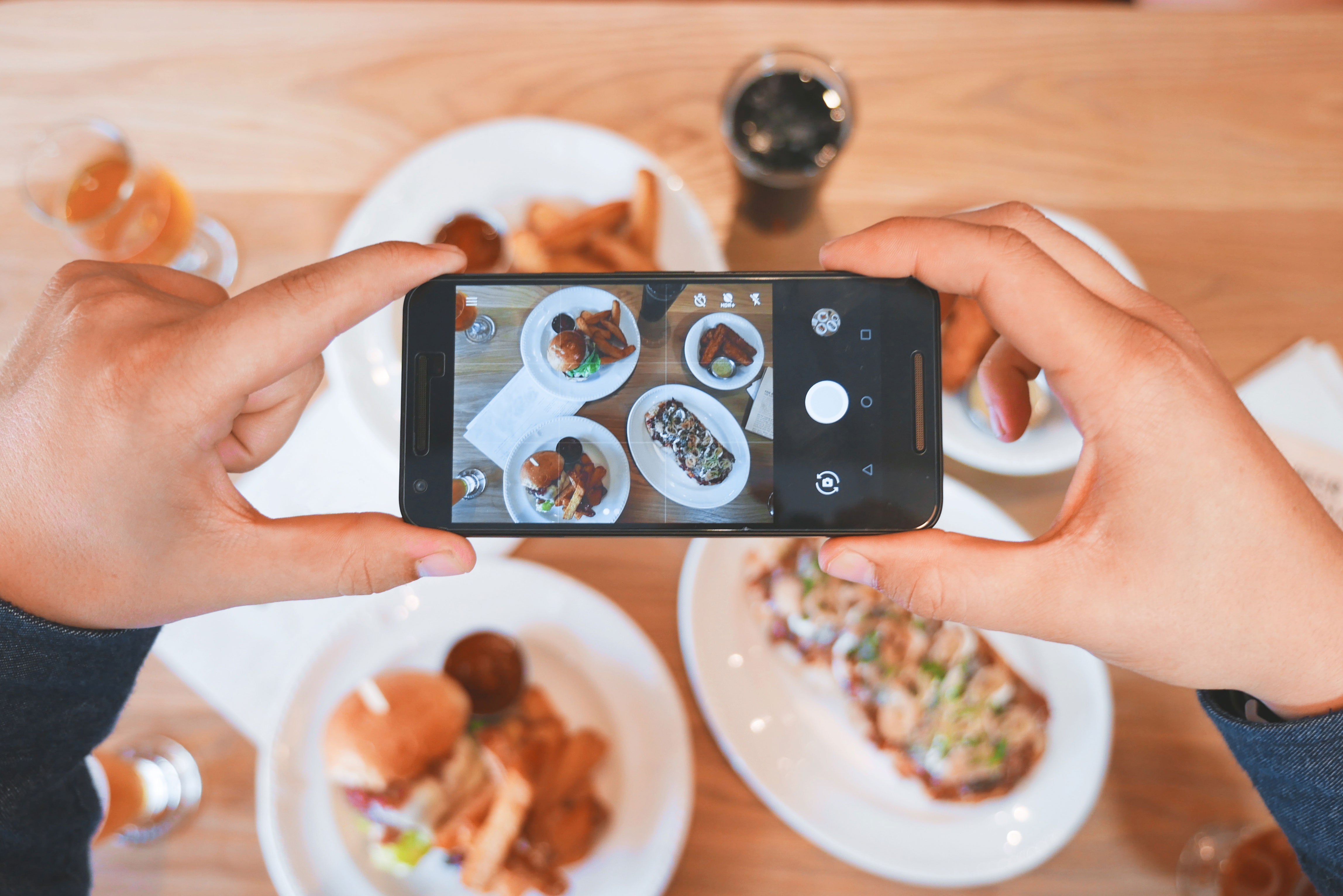 a person taking a cell phone picture of their food